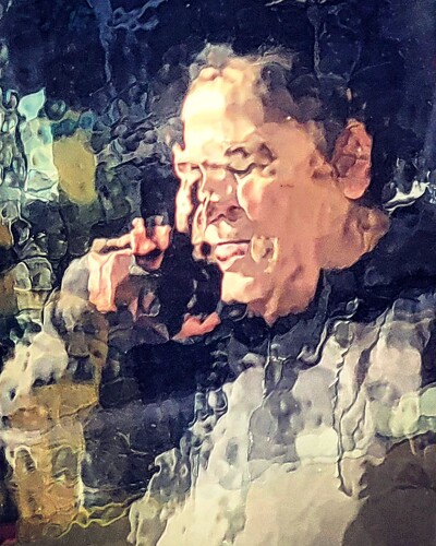 Photo of a reflection of a man speaking on a phone