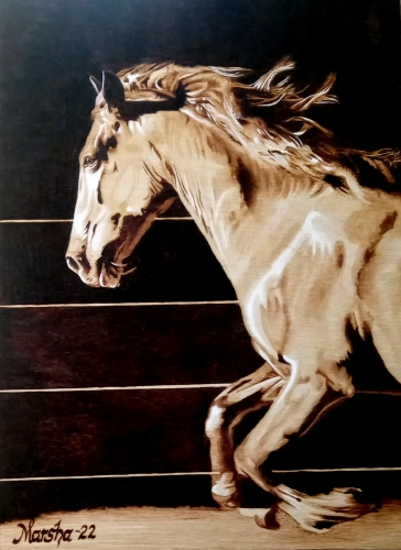 pyrography artwork of a horse running