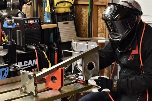 an artist welding metal in a studio