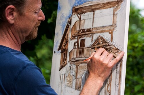 photograph of an artist at work on a painting