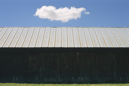 fine art photo of a barn and lone cloud in the sky