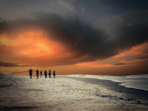 dramatic sunset photograph of a group on a beach