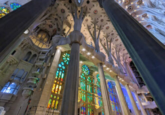 photograph of stained glass windows and soaring church walls