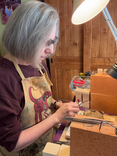 jewelry artist working with a torch